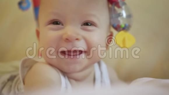 快乐的小男孩微笑着玩玩具躺在床上合上可爱的5个月大宝宝笑视频的预览图