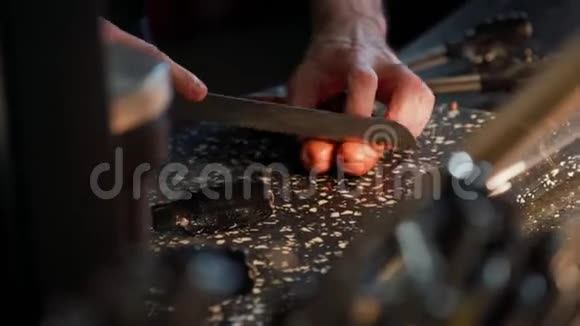 厨师在黑石板上用锋利的刀切香肠做快餐在厨房做饭视频的预览图