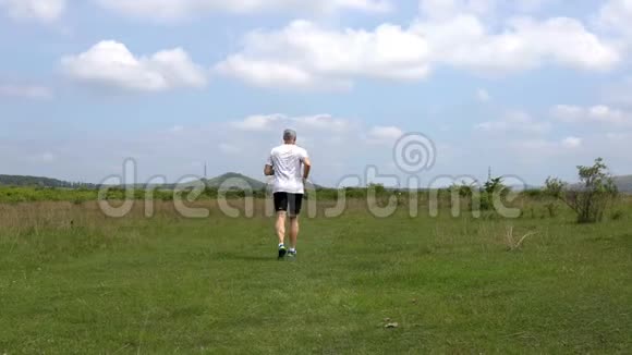 春天中年运动男子在草地上奔跑视频的预览图