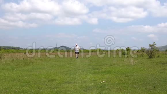 春天中年运动男子在草地上奔跑视频的预览图