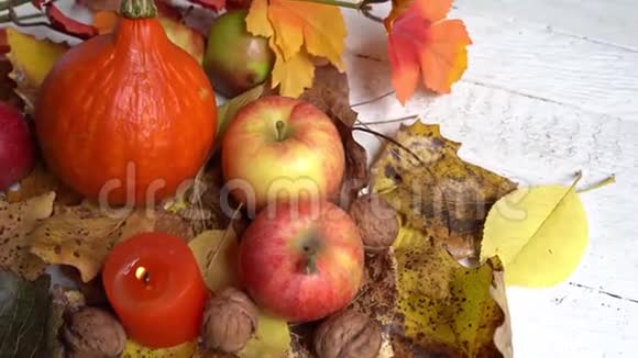 木桌上的秋叶蜡烛苹果南瓜感恩节问候背景视频的预览图