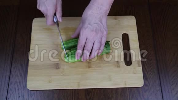 用手在木制的色拉砧板上切青瓜食物视频的预览图