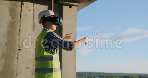建筑工程师用vr眼镜和vr眼镜将建筑平面图立在建筑的屋顶上视频的预览图