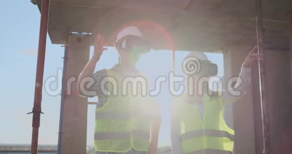 一个男人和一个女人在一个建筑工地的VR眼镜管理着一座建筑的建造讨论着一个视频的预览图