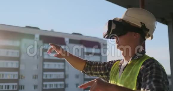 工程师Builder用VR眼镜和VR镜将建筑平面图立在建筑的屋顶上视频的预览图