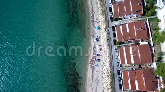 鸟瞰海岸线水晶般清澈的绿松石水域和小海滩旁边的旅游住宅希维里哈尔基迪基希腊视频的预览图
