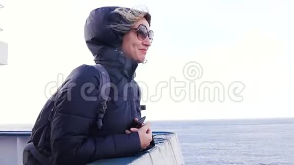 一个戴着眼镜的金发女人正在汽船上航行游客母亲和家人一起在水上散步大海河流轮廓视频的预览图