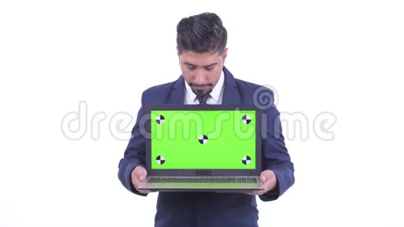 一个满脸胡须的波斯商人在展示笔记本电脑时说话视频的预览图