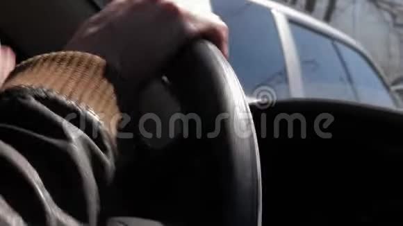 在驾驶汽车的皮夹克男子方向盘上的特写视频的预览图