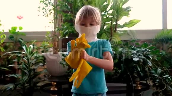 戴着防护面罩和防护橡胶手套的小可爱女孩视频的预览图