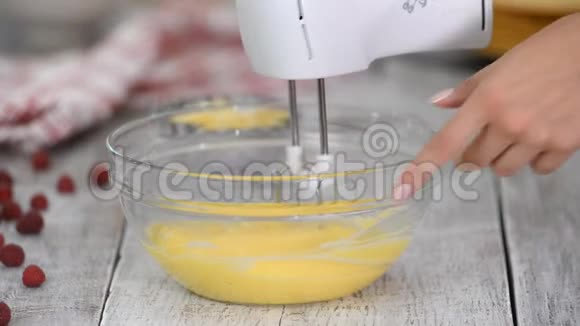 烹饪和家居理念特写镜头女人用手搅拌器打蛋羹甜奶油的配制视频的预览图