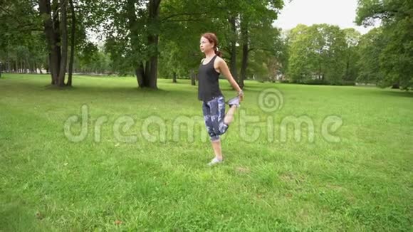 年轻运动女子在慢跑前在公园锻炼视频的预览图