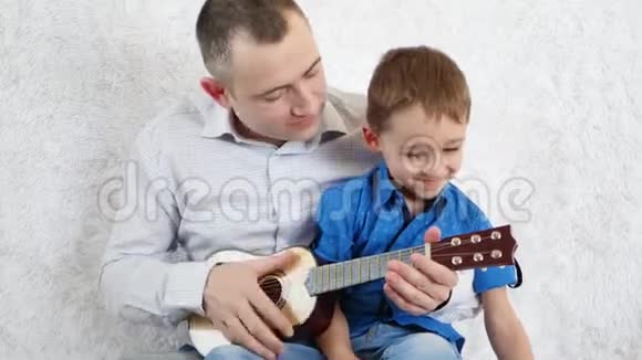 父子俩弹吉他唱歌幸福家庭的概念视频的预览图