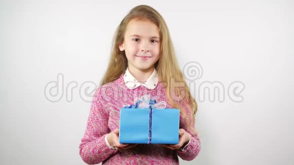 一位面带微笑的迷人女孩向镜头伸出双臂送上礼物视频的预览图