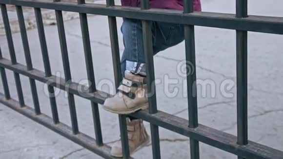 小女孩的脚在篱笆上爬模糊的形象视频的预览图
