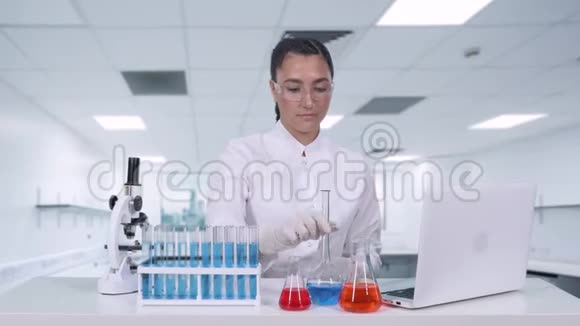 一位女性研究员分析瓶中的液体并进行临床试验女性科学家进行遗传视频的预览图