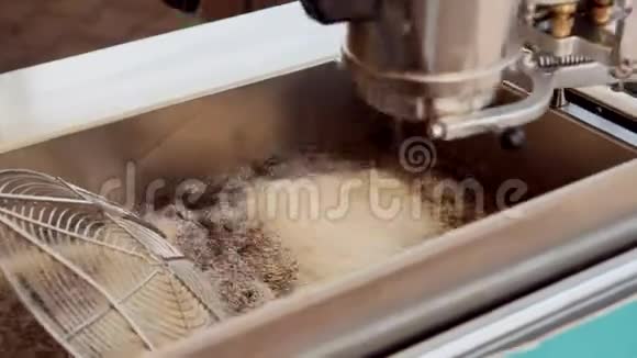 面团在深油炸锅里煮油厨师在搅拌视频的预览图