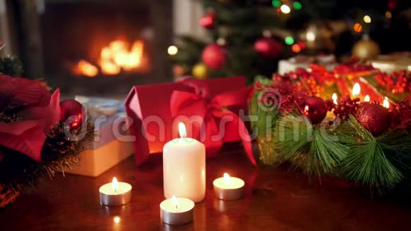 特写4k段蜡烛燃烧的镜头圣诞老人赠送的礼物和圣诞树上的礼物花环视频的预览图