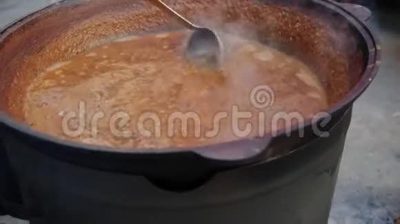 厨师用勺子搅动传统的美国锅视频的预览图