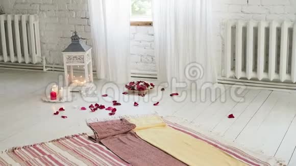 玻璃花瓶里的玫瑰和蜡烛房间里地板上的花蜡烛和玫瑰花瓣浪漫的夜晚视频的预览图