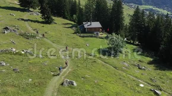在瓦莱州的瑞士阿尔卑斯山一群骑着电动自行车的山地自行车爱好者在阳光明媚的天气中的鸟瞰图视频的预览图