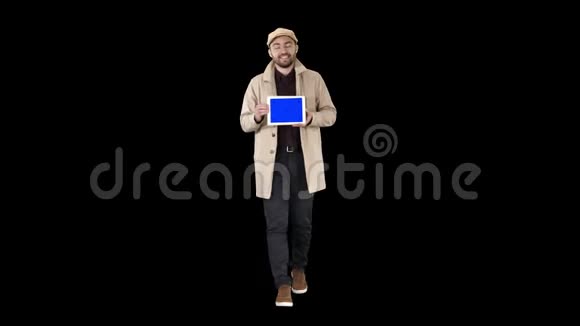 年轻人走路说话展示带有蓝色屏幕模型的数字平板电脑阿尔法频道视频的预览图