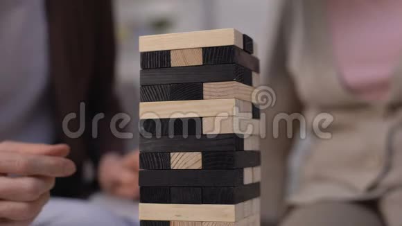 高级妇女从塔楼上拿木头玩休闲游戏特写视频的预览图