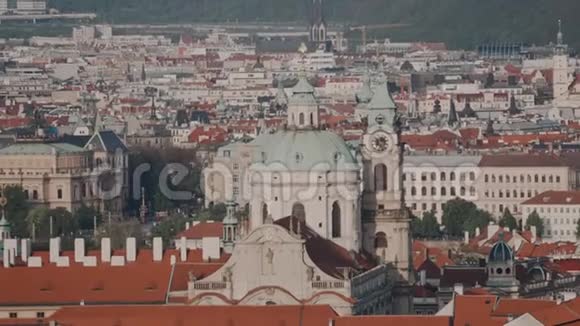 从布拉格最著名的巴洛克教堂圣尼古拉斯教堂和传统的捷克教堂顶部可以看到美丽的景色视频的预览图