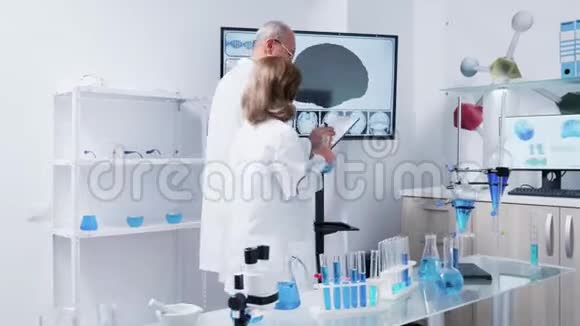 在现代实验室中女性和男性科学家正在行走视频的预览图