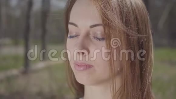 森林里一位棕色头发的优雅可爱的年轻女子的特写肖像视频的预览图
