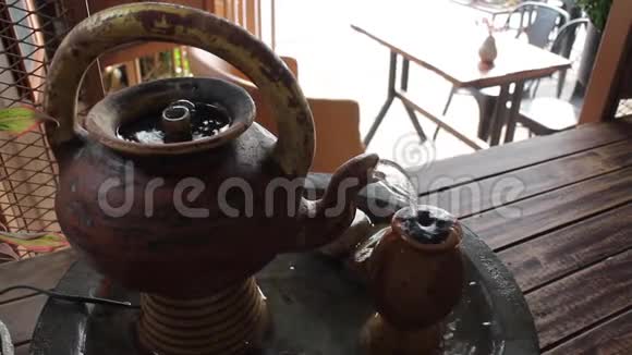 用水在咖啡馆里流动的烤泥茶壶视频的预览图