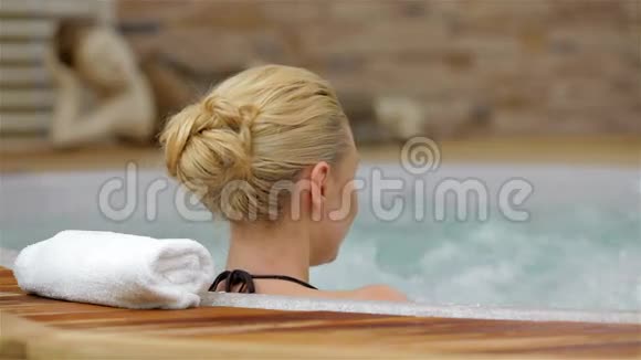 一个享受按摩浴缸的女人的后景视频的预览图