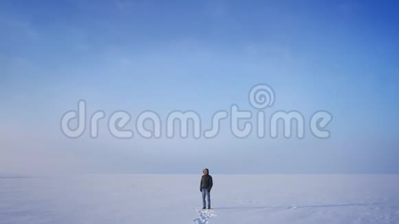 放大照片中的中年探险家在雪漠背景下微笑地观看镜头视频的预览图