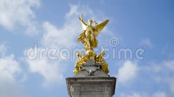 维多利亚纪念碑在白金汉宫的蓝云背景行动白金汉宫前维多利亚女王纪念碑视频的预览图