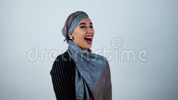 年轻美丽的阿拉伯女人在孤立的白色背景上放声大笑视频的预览图