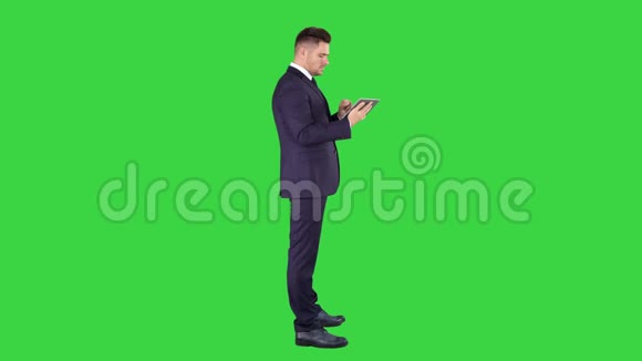 聪明的高级商人使用绿色屏幕上的技术平板电脑色度键视频的预览图