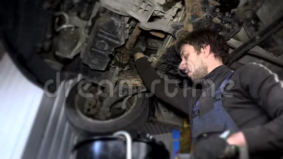 维修过程中肮脏的汽车修理工将磨损的滤油器拧下视频的预览图