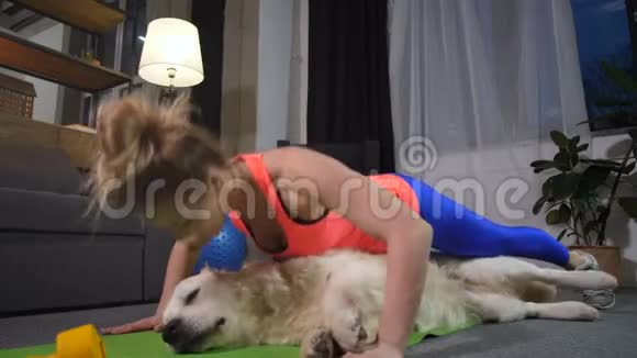 健康的女人做俯卧撑和宠物狗视频的预览图