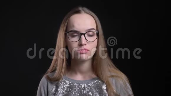 年轻迷人的戴眼镜的时髦女性特写镜头皱着眉头怀疑和沮丧地直视着视频的预览图