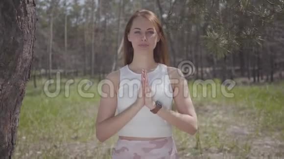 美丽的女人用祈祷的手在令人惊叹的壮丽的绿色森林中祈祷视频的预览图