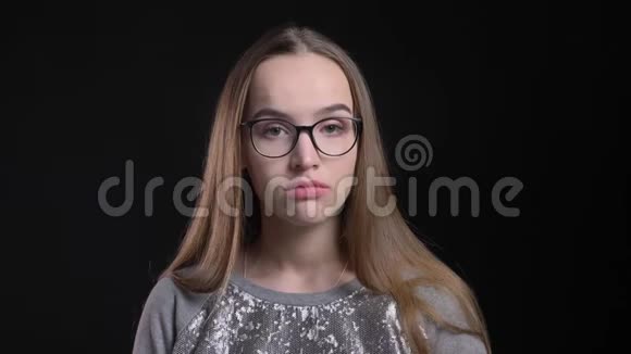 年轻迷人的时髦女性戴着眼镜的特写镜头无聊而无趣地直视镜头视频的预览图