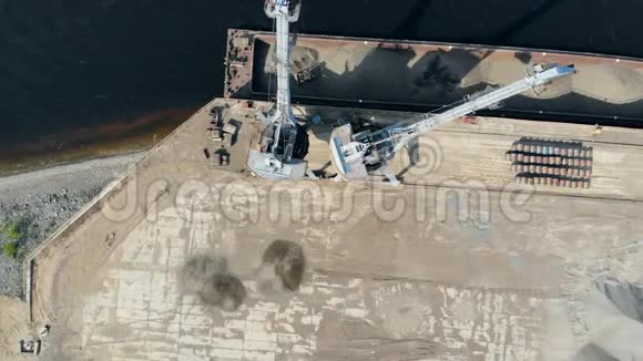 一辆起重机把碎石堆在港口的一堆里视频的预览图