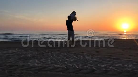男人把小女孩抱在靠近大海的肩膀上视频的预览图