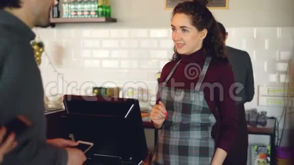 顾客在现代咖啡店购买外卖咖啡用智能手机支付非接触式付款视频的预览图