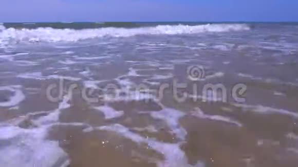 在阳光明媚的日子里沙滩上有长时间的大浪和脏水视频的预览图