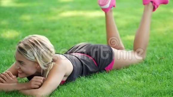 嘲笑公园里的男人和女人调情运动情侣躺在草地上视频的预览图