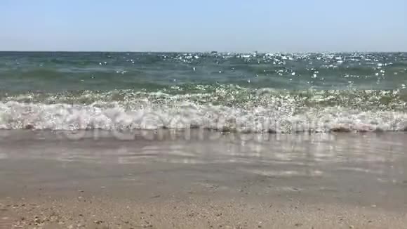在日落或日出的沙滩背景下阳光灿烂的海水和成年男子跳进水中视频的预览图