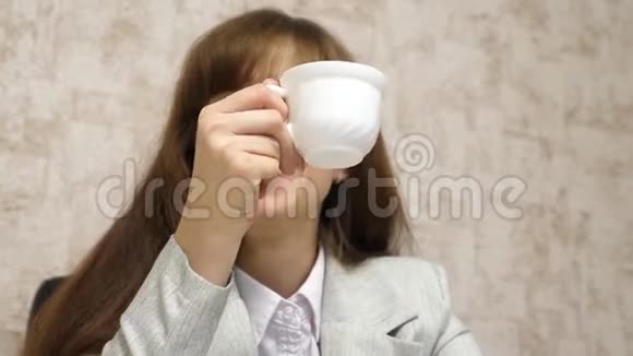 美丽的女孩坐在办公室的椅子上说话喝着白色杯子里的茶青年女企业家视频的预览图