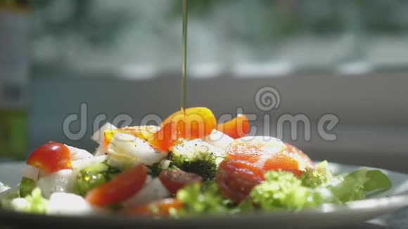 在新鲜的春天沙拉上缓慢地倒入橄榄油天然素食沙拉有机食品的健康生活方式视频的预览图