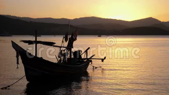船靠近岸映衬着山峦和美丽的夕阳浪漫的气氛镇静和安抚视频的预览图